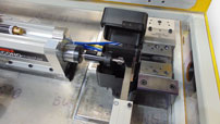 Close-up view of Manchester Tool and Die Model M25 tube deburring machine cutting head and tube positioning system